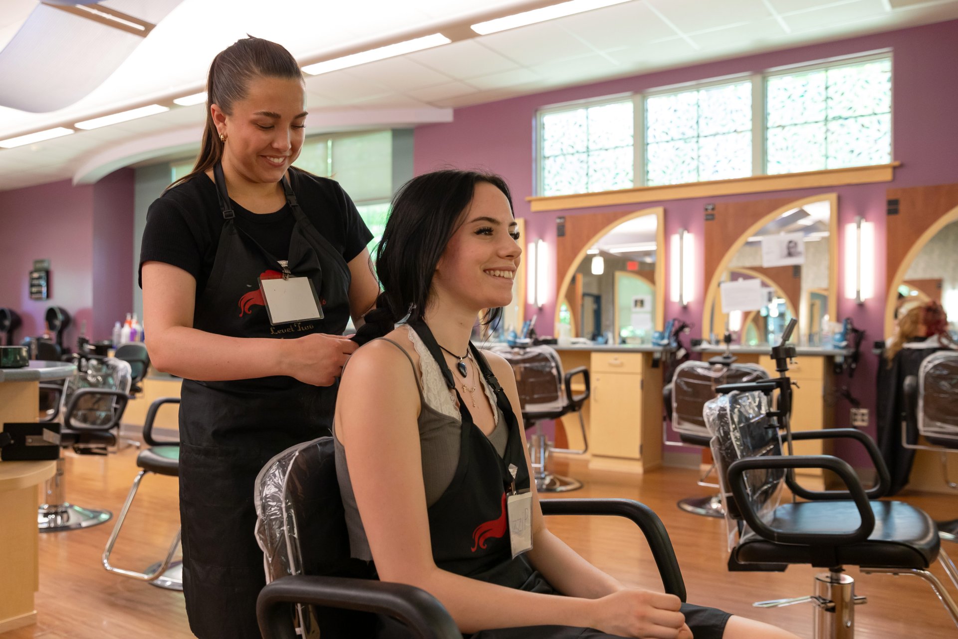 Cosmetology students practicing hairstyles.