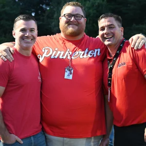 Three staff members standing together and smiling.