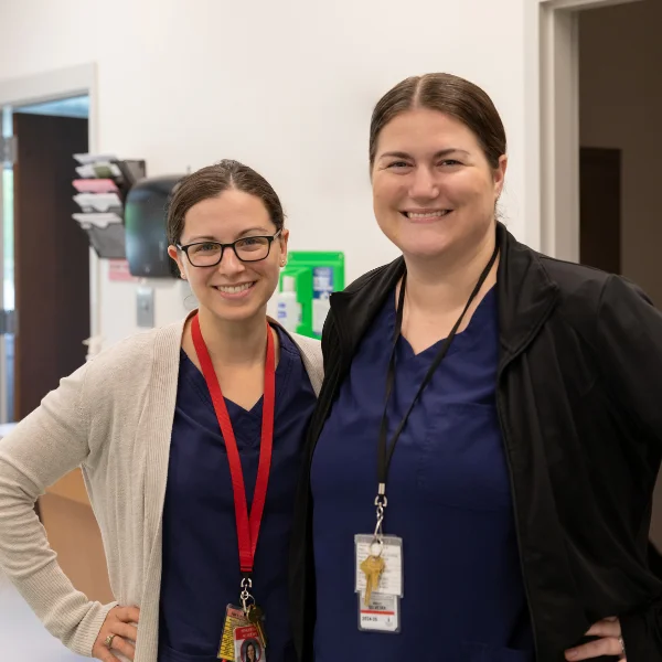 Two nurses smiling and posing together.