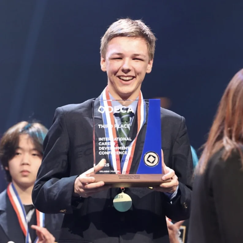 Pinkerton DECA member, Nicholas Goyette holding a 3rd place trophy.